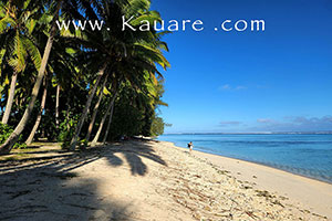 two red sea-kayaks on the beach beside Aitutaki Lagoon